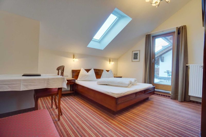 Schlafzimmer mit Doppelbett und Balkon Apartment K
